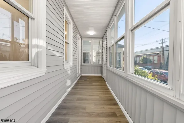 a view of a large room with wooden floor and windows