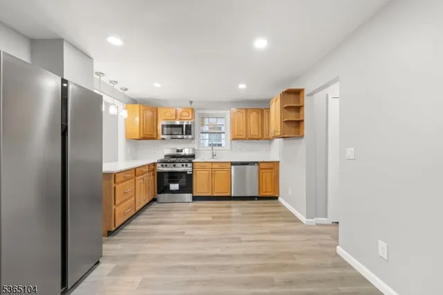 a kitchen with stainless steel appliances granite countertop a refrigerator and a sink