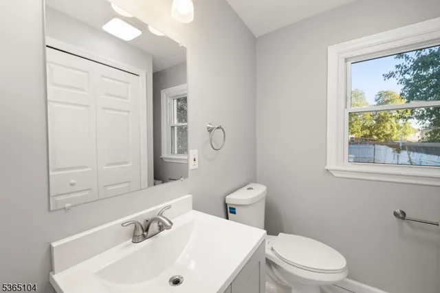 a bathroom with a sink a toilet and a mirror