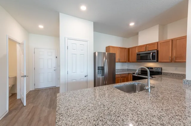 a kitchen with stainless steel appliances granite countertop a refrigerator and a sink