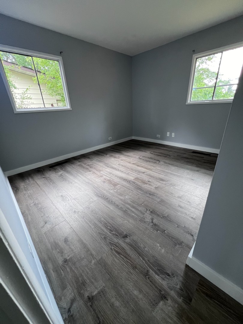 342 Greenwood Road Glenview, IL 60025 - Photo 7 of 11 an empty room with wooden floor and windows