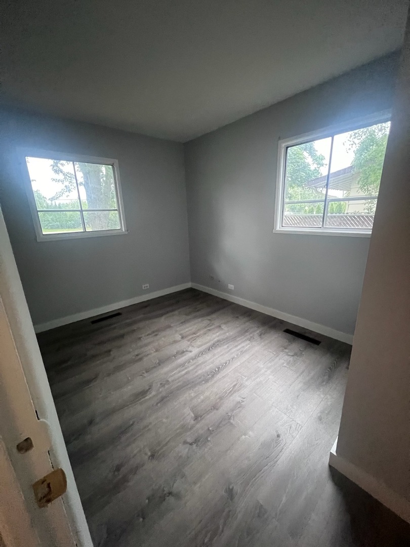 342 Greenwood Road Glenview, IL 60025 - Photo 8 of 11 an empty room with wooden floor and windows