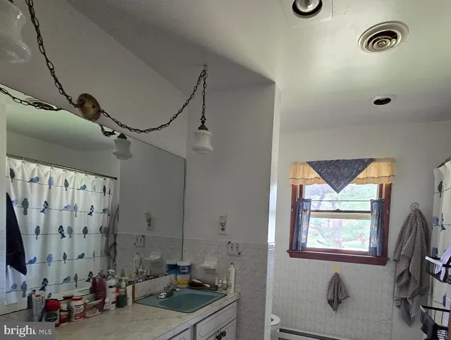 a bathroom with a granite countertop sink a mirror and shower