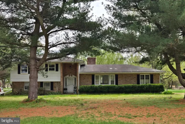 a front view of a house with a garden and trees