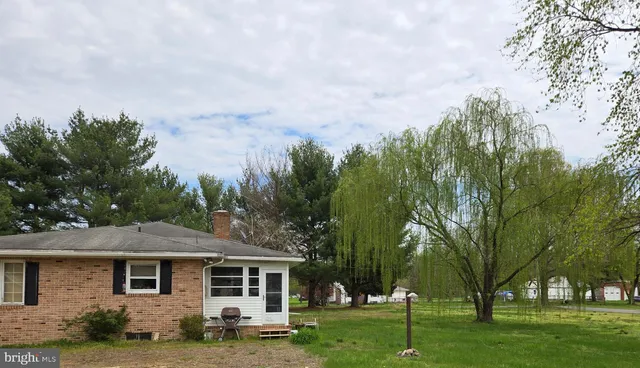 a front view of a house with a yard and trees