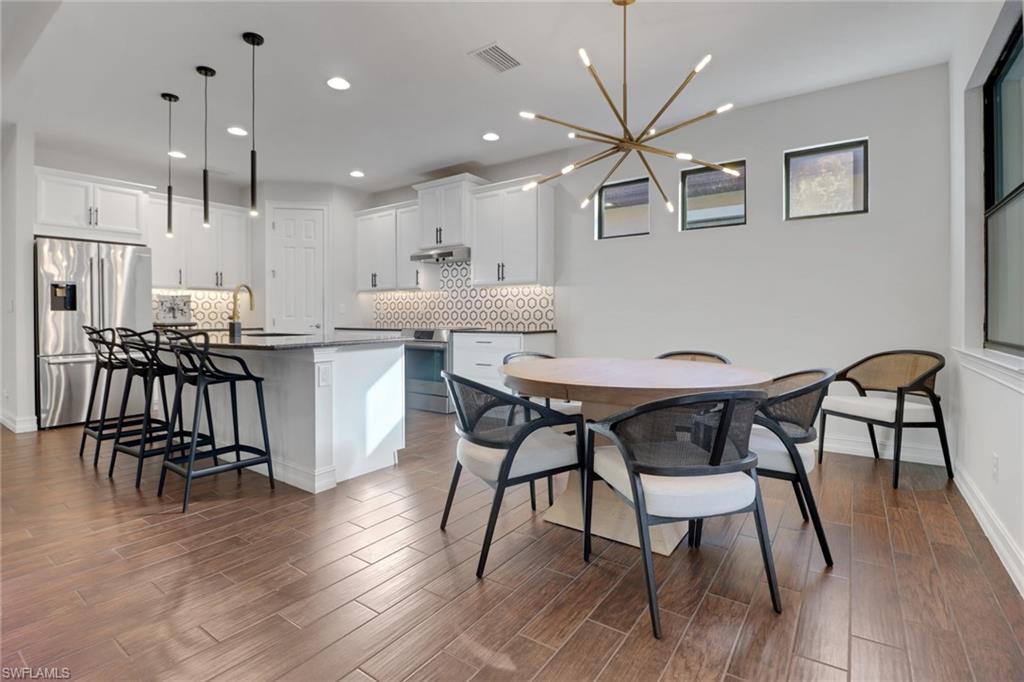 14374 Tuscany Pointe Trail Naples, FL 34120 - Photo 15 of 38 a view of a dining room with furniture and wooden floor
