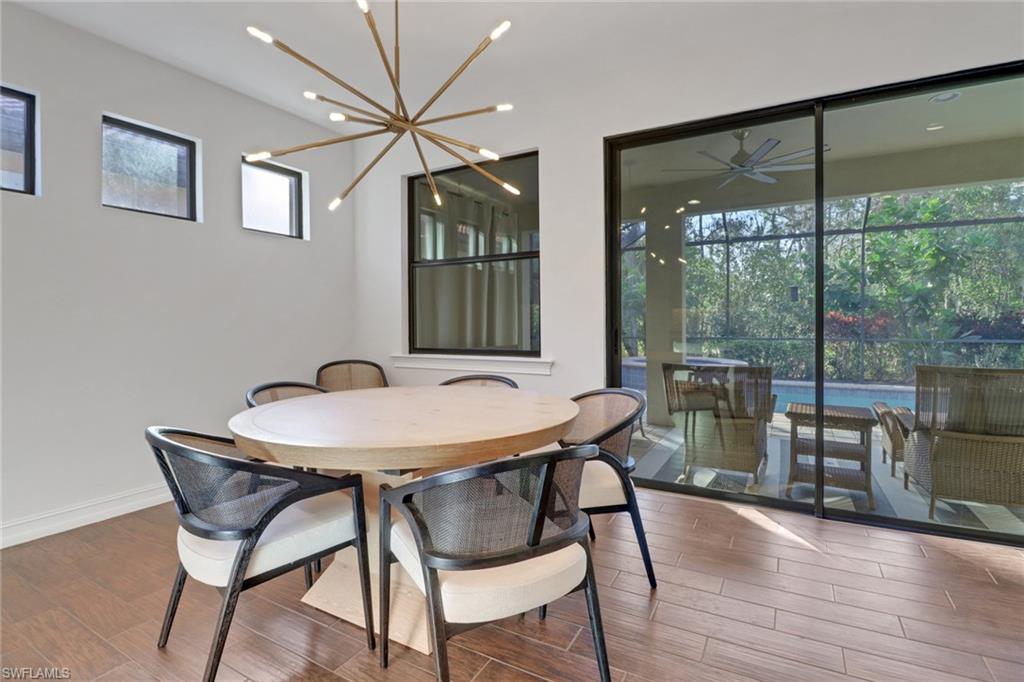 14374 Tuscany Pointe Trail Naples, FL 34120 - Photo 16 of 38 a view of a dining room with furniture window and wooden floor