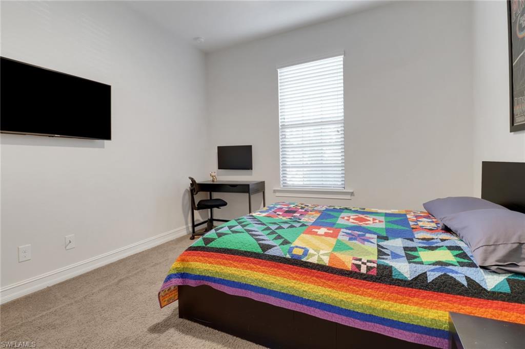 14374 Tuscany Pointe Trail Naples, FL 34120 - Photo 18 of 38 a room that has a bed and a chair in it