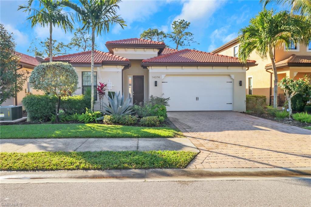 14374 Tuscany Pointe Trail Naples, FL 34120 - Photo 2 of 38 a front view of a house with a garden and palm trees