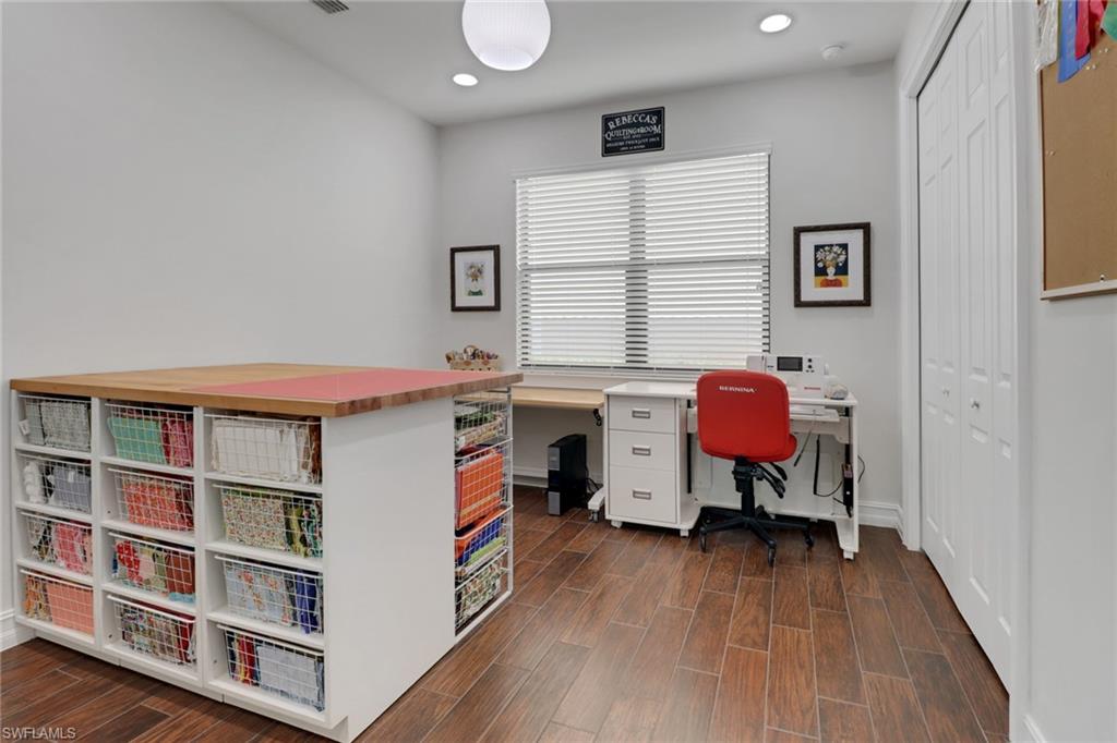14374 Tuscany Pointe Trail Naples, FL 34120 - Photo 23 of 38 a view of a workspace with furniture and wooden floor
