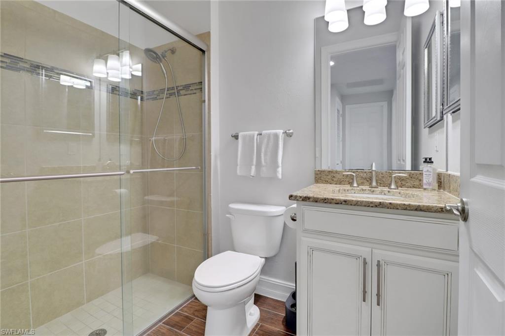 14374 Tuscany Pointe Trail Naples, FL 34120 - Photo 25 of 38 a bathroom with a granite countertop sink toilet and shower
