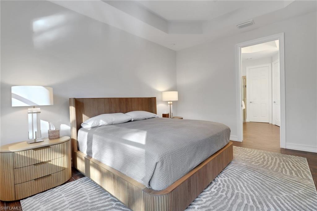 14374 Tuscany Pointe Trail Naples, FL 34120 - Photo 30 of 38 a bedroom with a bed and wooden floor