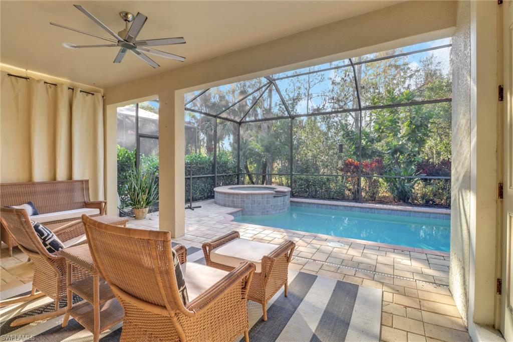 14374 Tuscany Pointe Trail Naples, FL 34120 - Photo 33 of 38 a living room with a floor to ceiling window and wooden floor