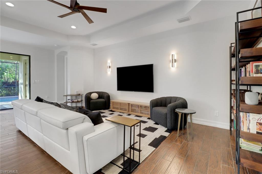 14374 Tuscany Pointe Trail Naples, FL 34120 - Photo 9 of 38 a living room with furniture and a flat screen tv