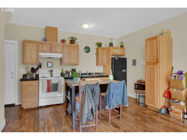 a kitchen view of dining table chairs and refrigerator