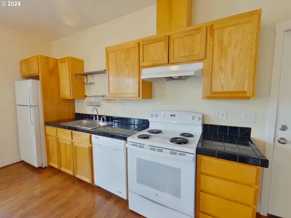 a kitchen with stainless steel appliances granite countertop a stove a sink and a refrigerator