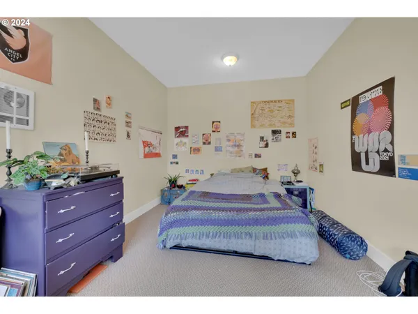 a bedroom with a bed and paintings on the wall