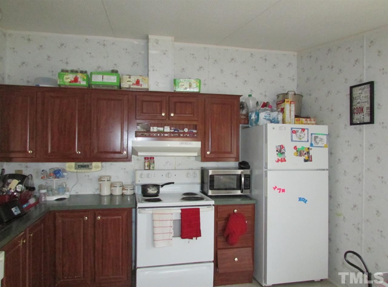 1294 Allensville Road Roxboro, NC 27574 - Photo 5 of 16 a kitchen with stainless steel appliances a refrigerator a sink and wooden cabinets