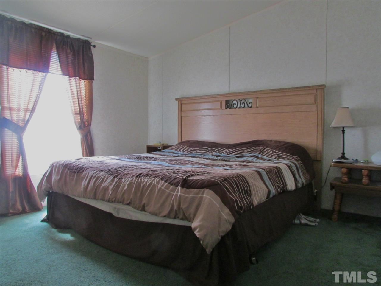 1294 Allensville Road Roxboro, NC 27574 - Photo 9 of 16 a bedroom with a bed and window