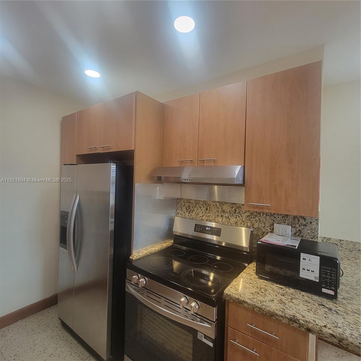 7400 Harding Avenue, Unit 15 Miami Beach, FL 33141 - Photo 3 of 29 a kitchen with granite countertop a refrigerator and a sink