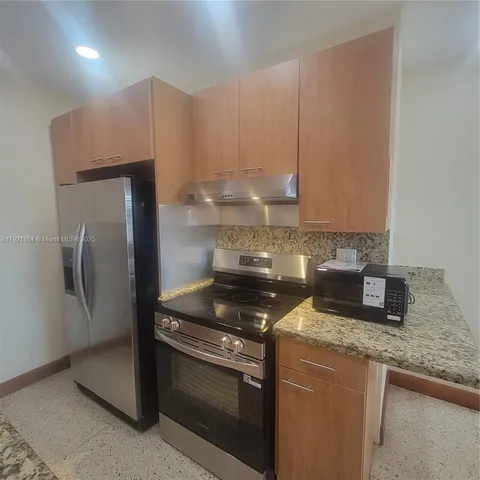 a kitchen with granite countertop a stove and a refrigerator