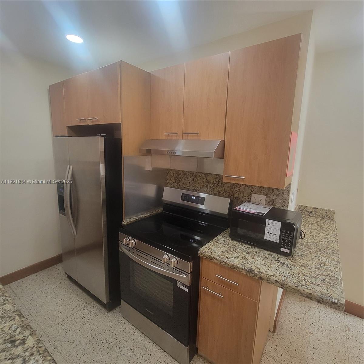 7400 Harding Avenue, Unit 15 Miami Beach, FL 33141 - Photo 8 of 29 a kitchen with granite countertop a sink a stove and a refrigerator