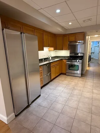 a kitchen with stainless steel appliances granite countertop a refrigerator and a stove
