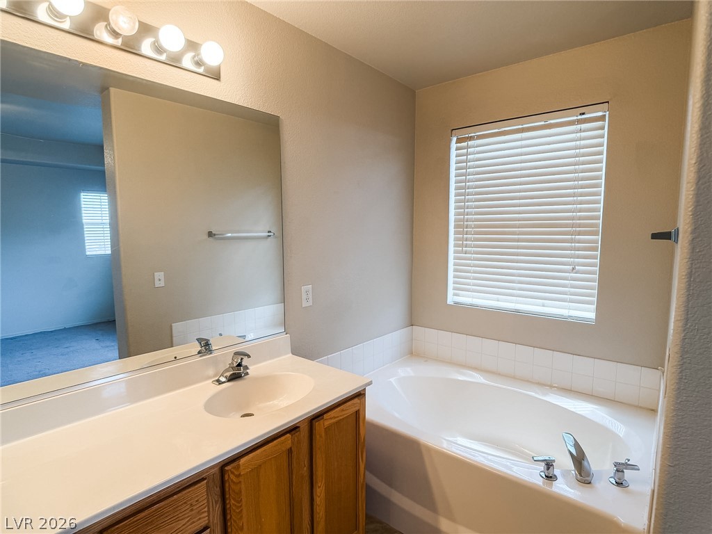 228 Positive Point Street Henderson, NV 89012 - Photo 17 of 27 Indulge in a generously sized soaking tub paired with a functional vanity, creating a serene personal retreat.