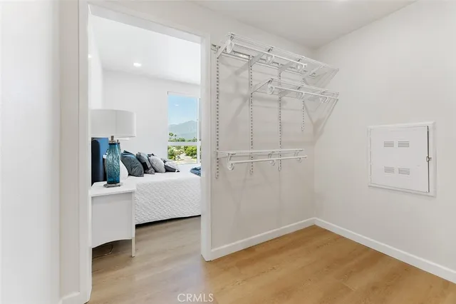 a view of an empty room with kitchen and a window