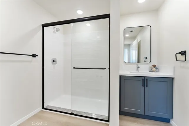 a bathroom with a shower sink and mirror
