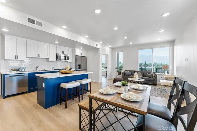 a view of a dining room with furniture a kitchen and chandelier