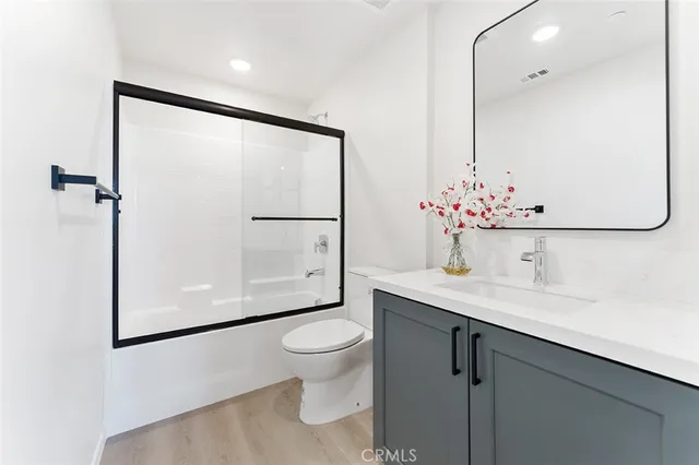 a bathroom with a granite countertop sink a toilet and a mirror