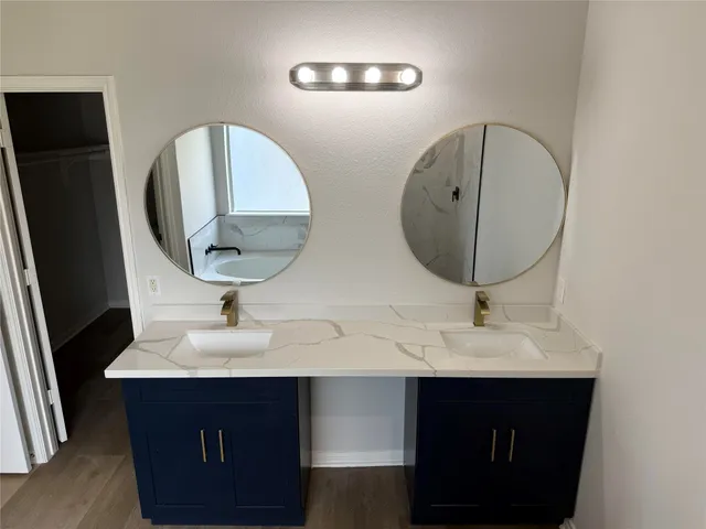 a bathroom with a double vanity sink and a mirror
