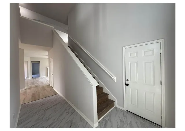 a view of a hallway with wooden floor and staircase