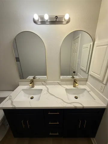 a bathroom with double sink and a mirror