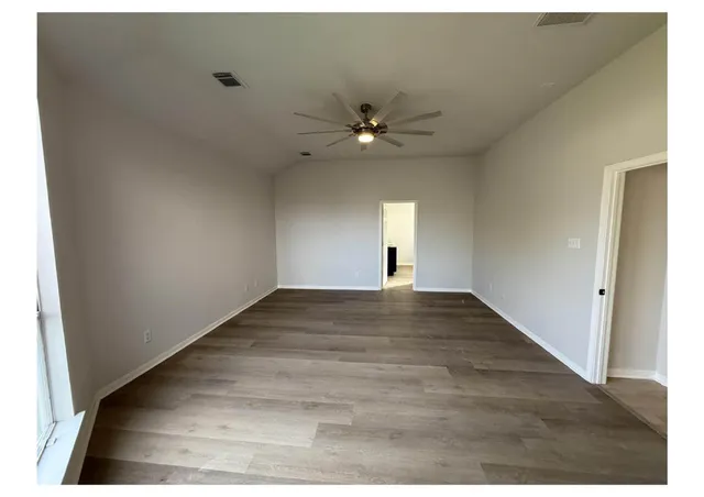 a view of empty room with wooden floor