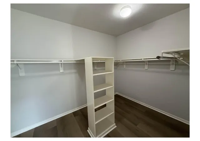 a view of walk in closet with empty racks