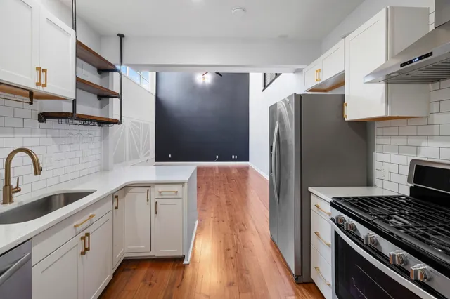 a kitchen with stainless steel appliances granite countertop a refrigerator and a sink