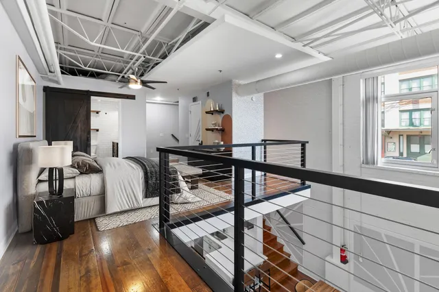 a view of a hallway with wooden floor and staircase
