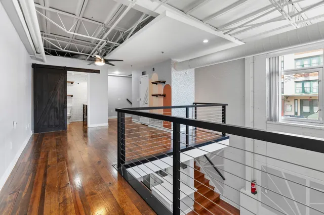 a view of a hallway with wooden floor and staircase