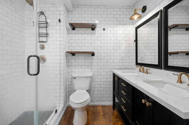 a bathroom with a granite countertop sink toilet and shower