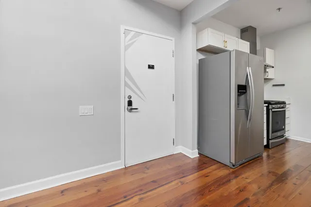 a view of a kitchen with wooden floor and a refrigerator