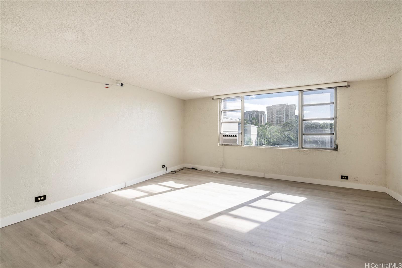 98-1030 Moanalua Road, Unit 5204 Aiea, HI 96701 - Photo 10 of 16 an empty room with wooden floor and windows