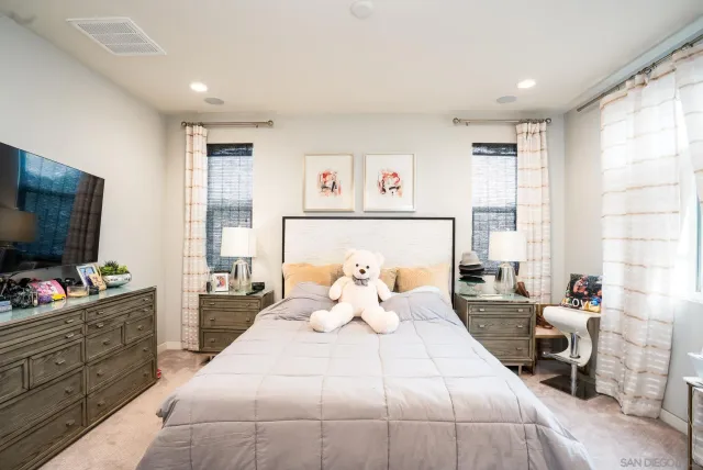 a spacious bedroom with a bed and a flat screen tv