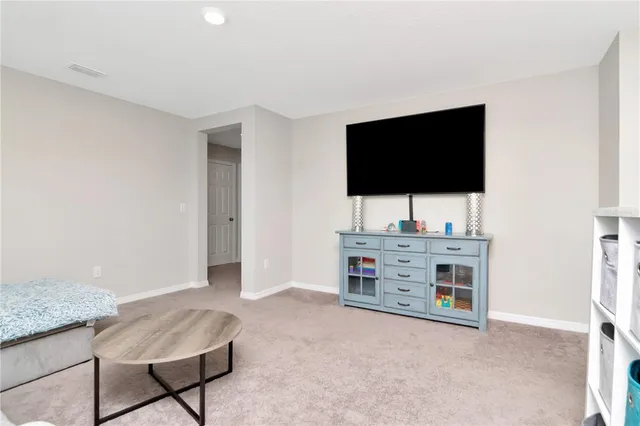 a spacious bedroom with a bed and a chandelier