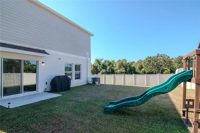 a view of a white house with a big yard