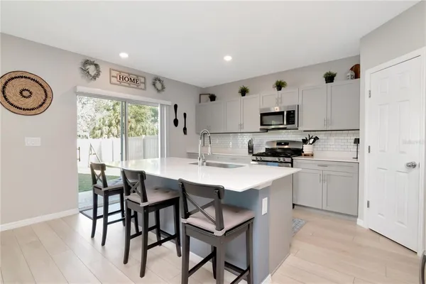 a kitchen with a dining table chairs and a refrigerator