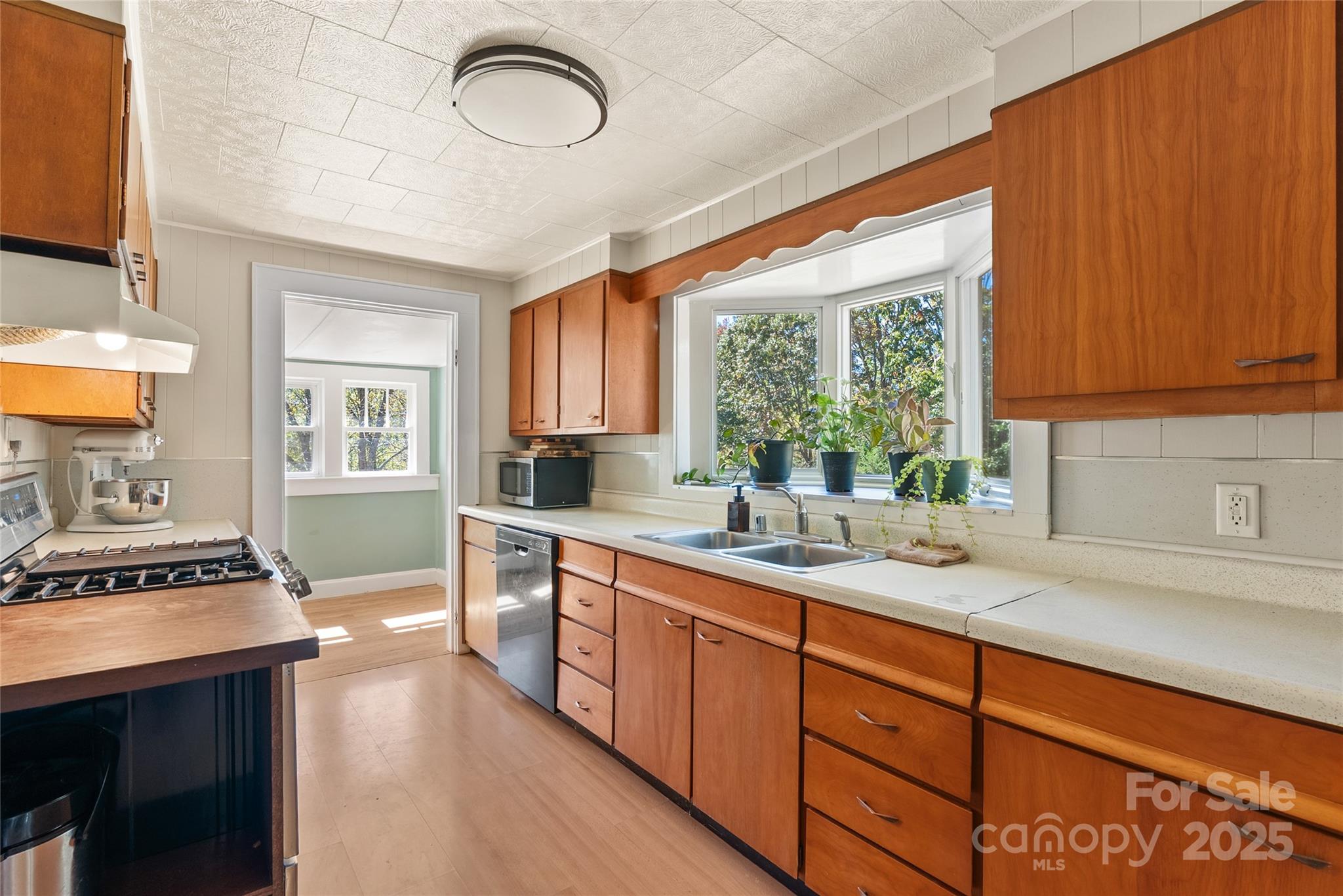 175 Candler School Road Candler, NC 28715 - Photo 21 of 37 a kitchen with stainless steel appliances a sink a stove a refrigerator cabinets and a window