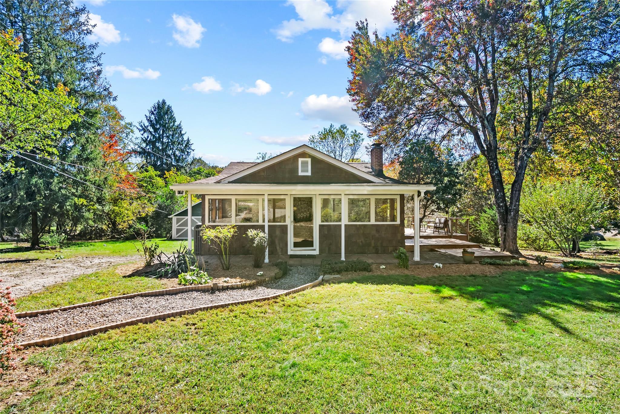 175 Candler School Road Candler, NC 28715 - Photo 4 of 37 a front view of a house with a yard table and chairs