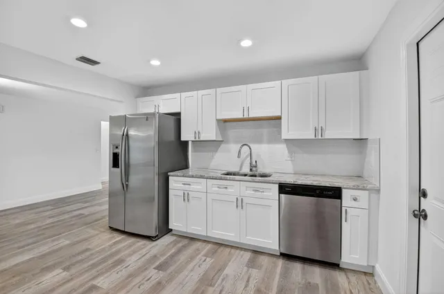 a kitchen with stainless steel appliances a refrigerator sink and cabinets